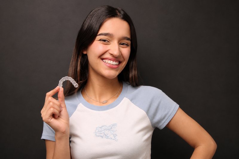 Teen holding an Invisalign aligner